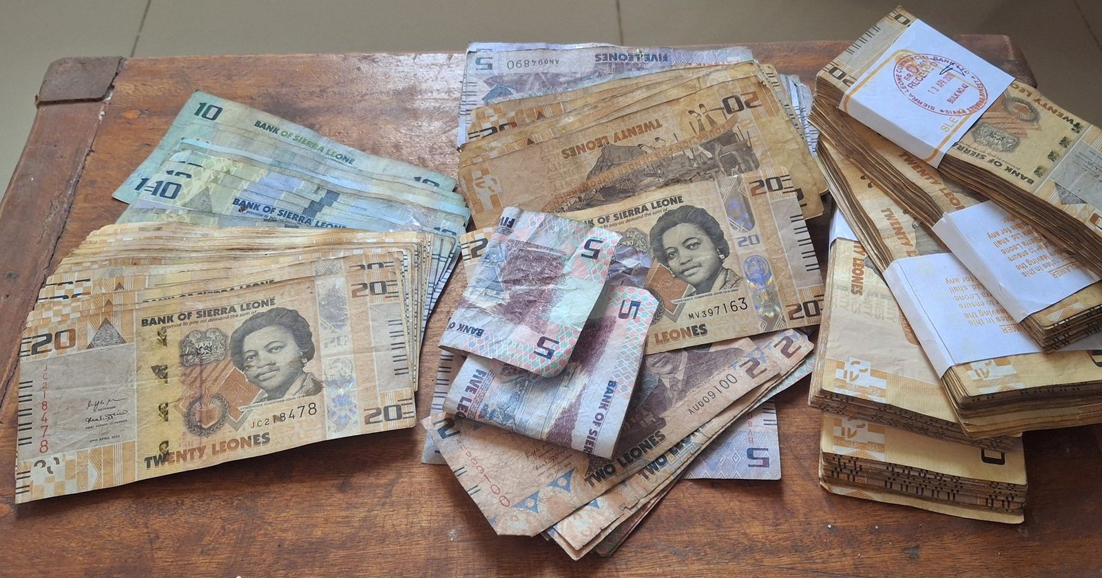 Sterta banknotów rozłożona na drewnianym stole — pieniądze publiczne i finansowanie ochrony zdrowia z budżetu