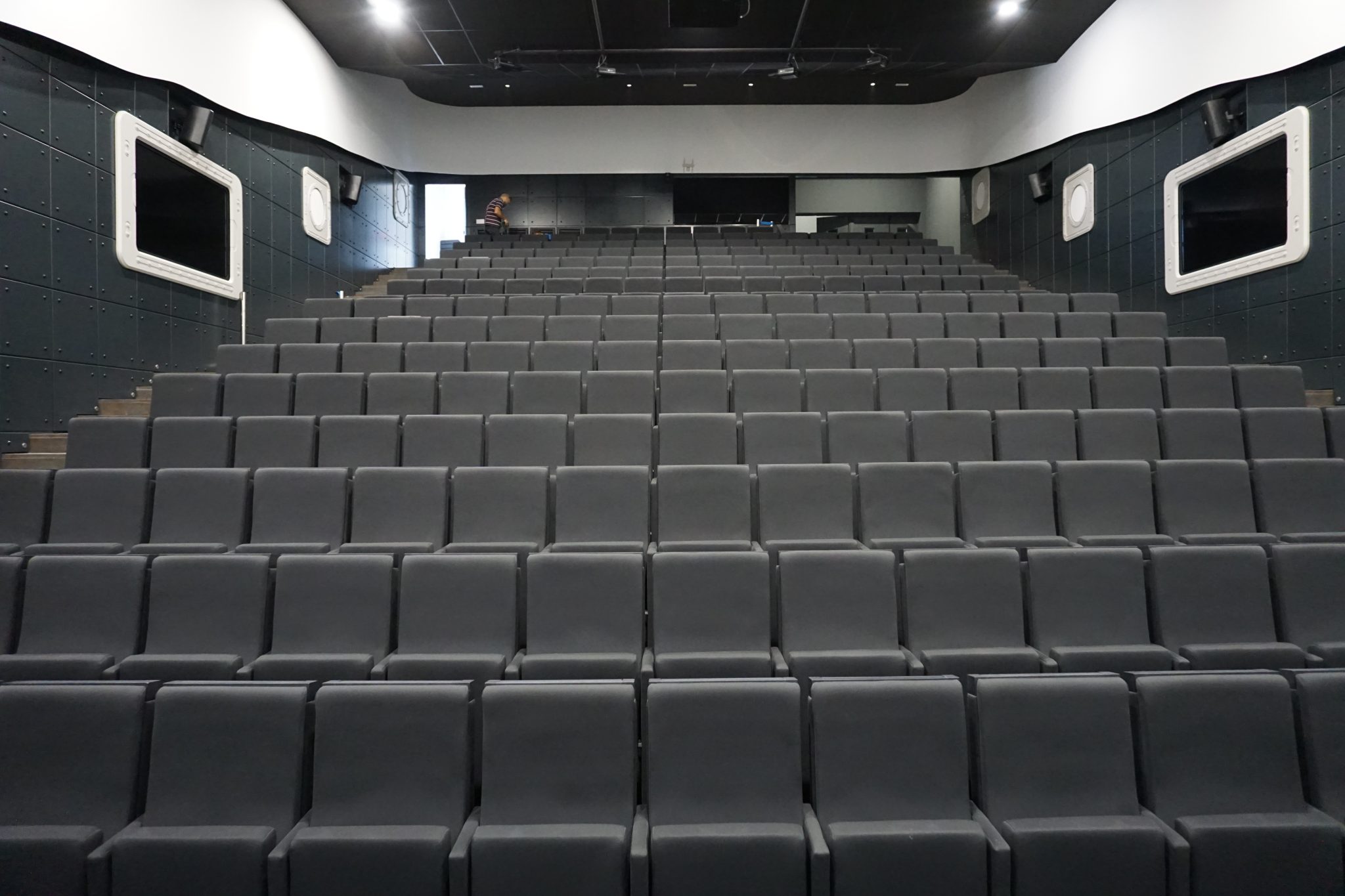 Pusta sala posiedzeń z rzędami krzeseł zwróconych ku podium — miejsce, w którym zbierają się organy spółki
